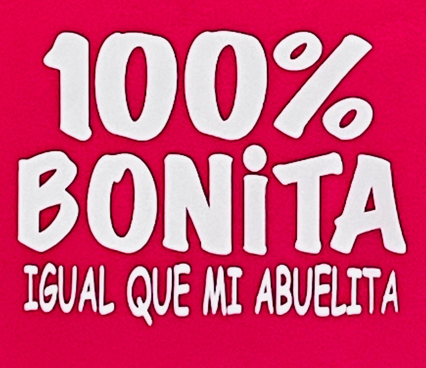 "100% Bonita Cómo Mi Abuelita" Youth Silkscreen T-Shirt in hot pink with bold black text, showcasing a playful and heartwarming design. Displayed flat with a clean background, available in sizes XS-XL. Perfect for kids who love their grandma!
