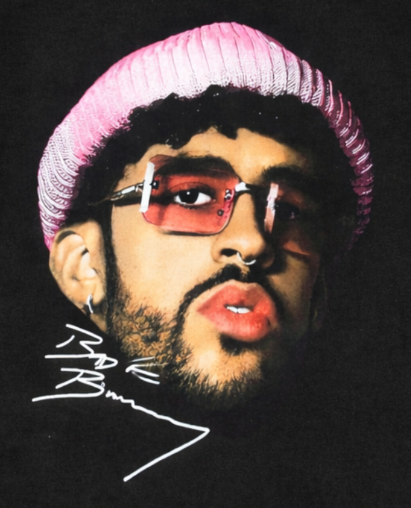 Front view of Bad Bunny Pink Beanie Portrait T-shirt featuring artist in pink knit hat and tinted glasses with signature printed in authentic silkscreen detail.