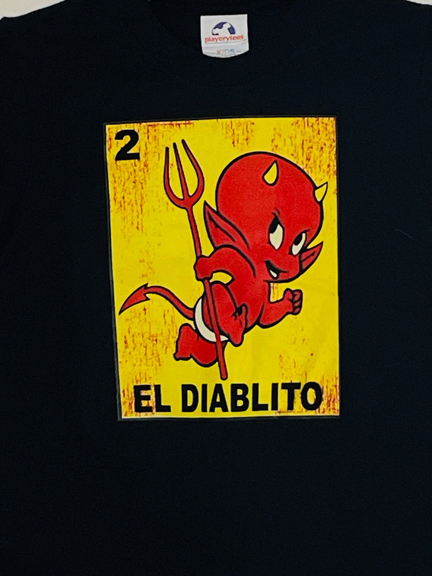 Youth t-shirt featuring the 'El Diablito card from the Mexican Lotería game, showcasing a red devil with a trident. Available in sizes XS-XL youth from JB Accessories05