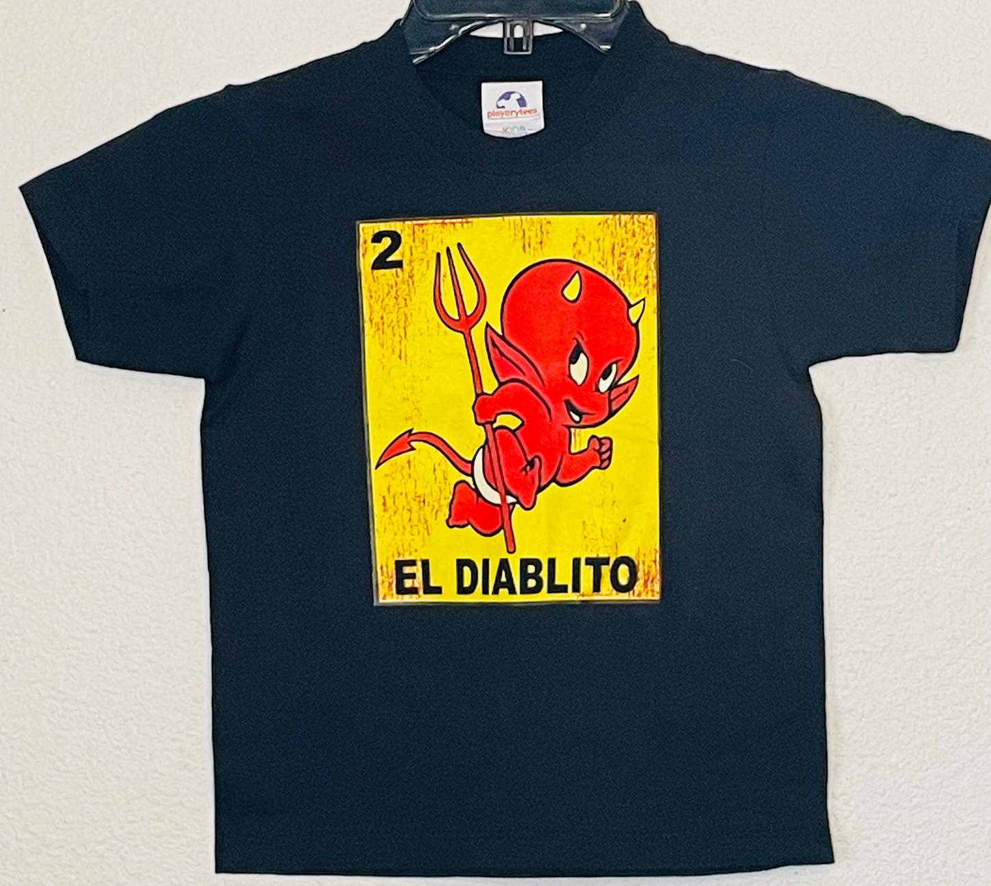 Youth t-shirt featuring the 'El Diablito card from the Mexican Lotería game, showcasing a red devil with a trident. Available in sizes XS-XL youth from JB Accessories05