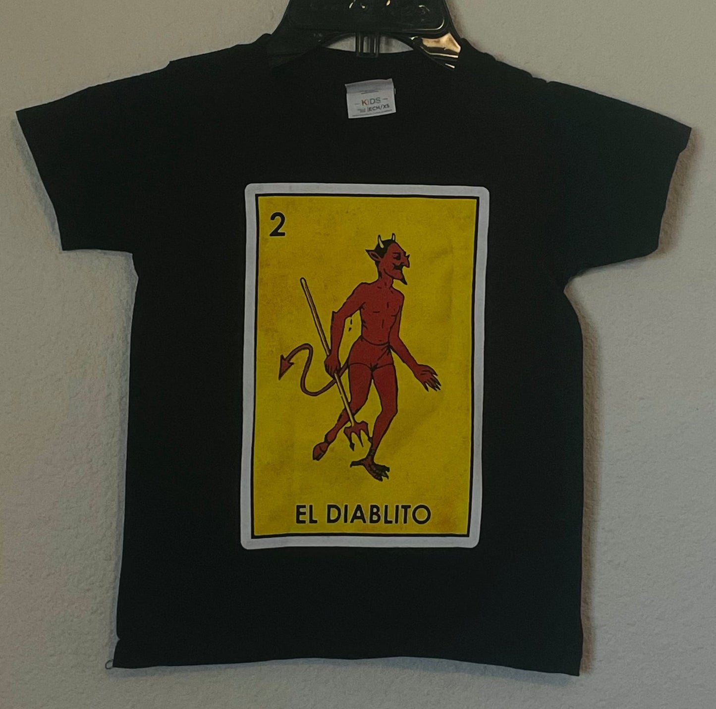 The "El Diablito (Skinny)" Boys Youth Silkscreen Novelty T-Shirt features a bold, playful graphic of El Diablito. Available in sizes XS-XL youth from JB Accessories05