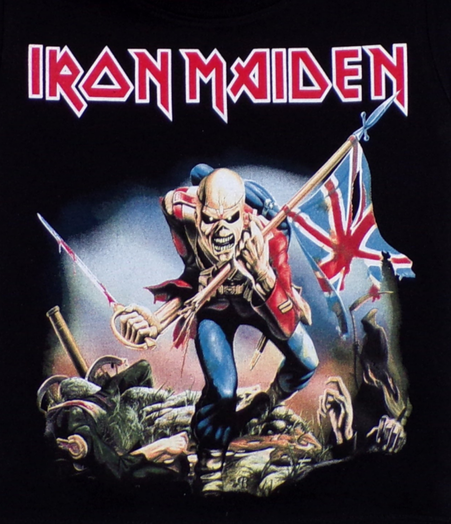 Iron Maiden 'The Trooper' Youth Silkscreen T-Shirt featuring vibrant artwork of Eddie, the band’s mascot, holding a British flag. The shirt is black, made from 100% cotton. Available in XS-XL