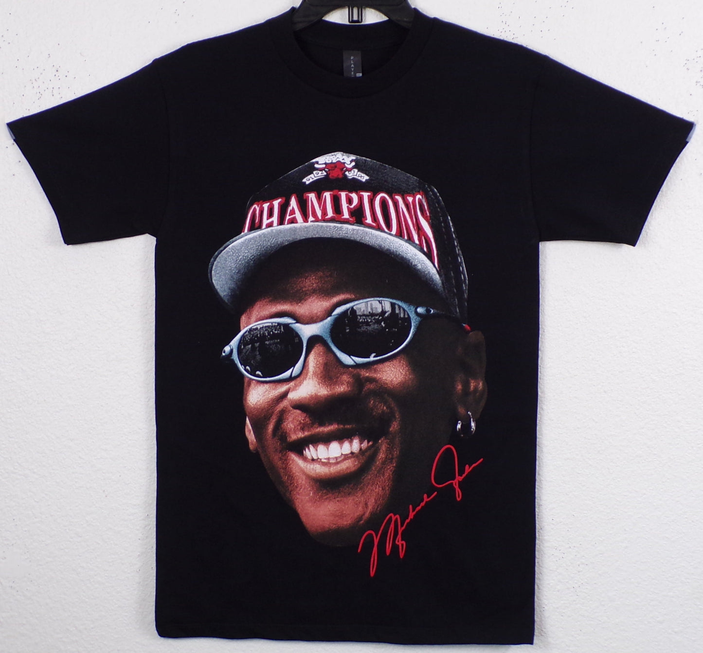 Black Michael Jordan “Champions” t-shirt with bold silkscreen print of MJ in cap and shades. Soft 100% cotton, unisex fit, Small–3XL.