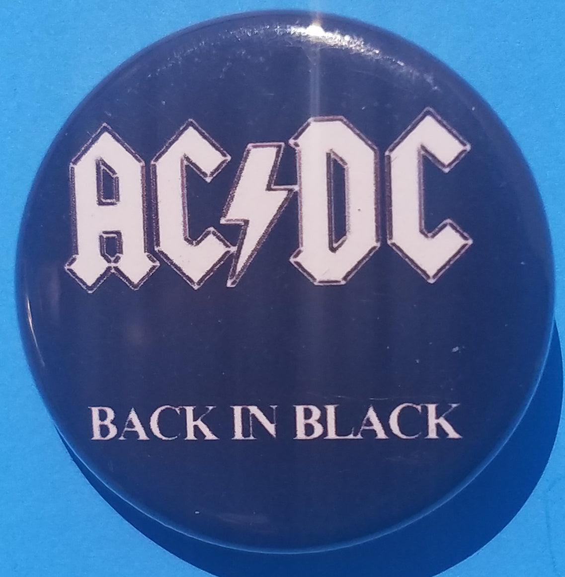 New AC/DC Button Set Of 7 Fashion Buttons Are 1.25" Inches In Size. Set Includes- 1. AC/DC Back In Black 2. AC/DC Brown Cannon 3. AC/DC Hells Bells 4. AC/DC Red Letter Logo On Black 5. AC/DC Red Letters With Face 6. AC/DC Stiff Upper Lip 7. AC/DC Who Made Who