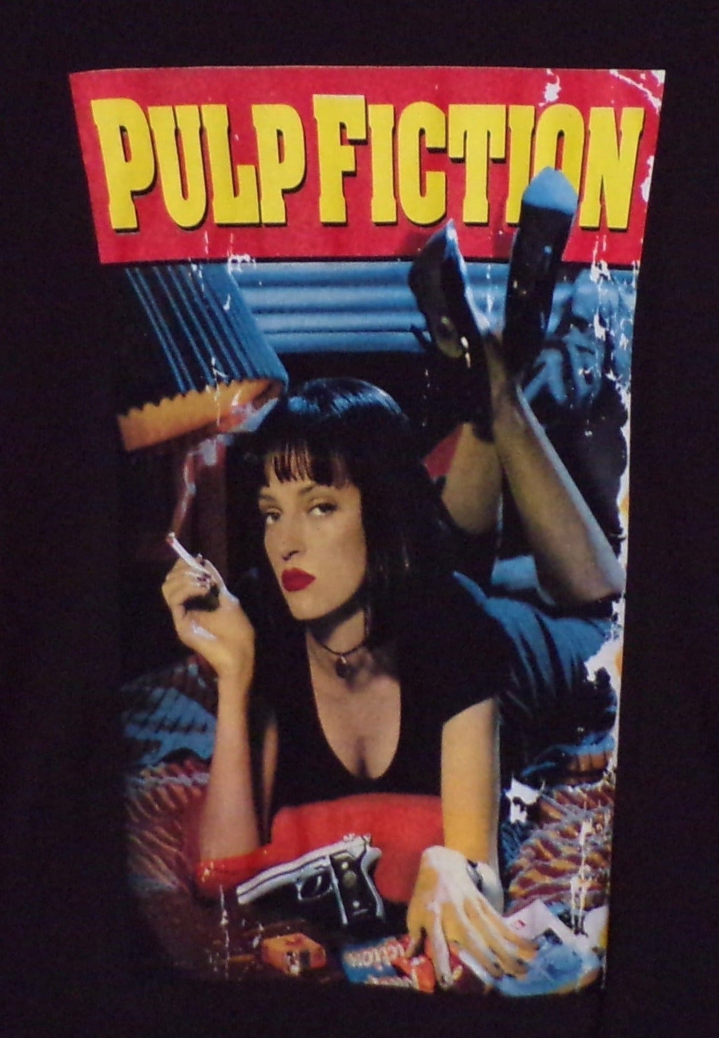 Black unisex “Pulp Fiction – Movie Cover” T-shirt featuring Mia Wallace movie poster artwork with bold red and yellow lettering, sizes Small–3XL.
