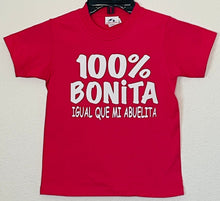 Load image into Gallery viewer,  &quot;100% Bonita Cómo Mi Abuelita&quot; Youth Silkscreen T-Shirt in hot pink with bold black text, showcasing a playful and heartwarming design. Displayed flat with a clean background, available in sizes XS-XL. Perfect for kids who love their grandma!                                                                                                    
