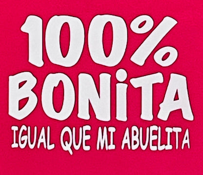  "100% Bonita Cómo Mi Abuelita" Youth Silkscreen T-Shirt in hot pink with bold black text, showcasing a playful and heartwarming design. Displayed flat with a clean background, available in sizes XS-XL. Perfect for kids who love their grandma!                                                                                                    