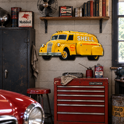 1938 Dodge Airflow Shell fuel tanker steel sign displayed above a red tool chest in a vintage automotive garage with Shell and gas station memorabilia.