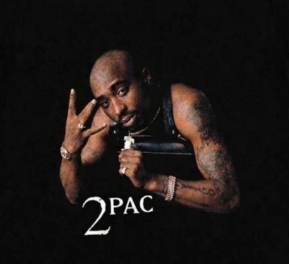 Close-up of the 2Pac – All Eyez on Me youth T-shirt showing the 1996 album-cover artwork, Westside hand sign, tattoos, jewelry, and 2PAC logo.