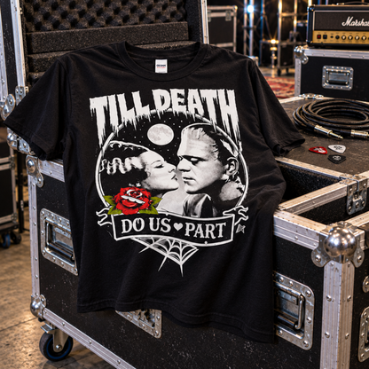 Till Death Do Us Part black T-shirt displayed on backstage road cases with an amp and audio gear, featuring Bride of Frankenstein and Frankenstein’s monster.