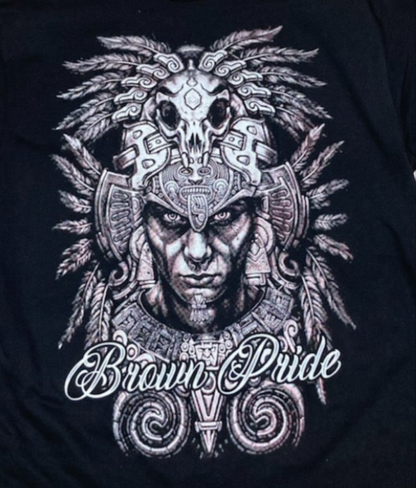 "Brown Pride" Adult Unisex Silkscreen T-Shirt featuring an intricate Aztec warrior design on a black background. Available in sizes Small-2XL.