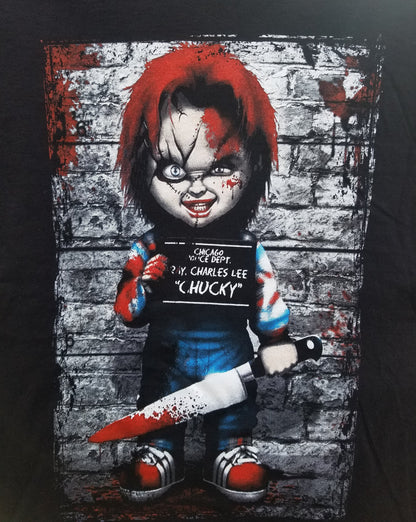 Front view of Chucky Mugshot T-shirt featuring horror doll graphic with bloody knife and mugshot background printed in authentic silkscreen on black cotton tee.