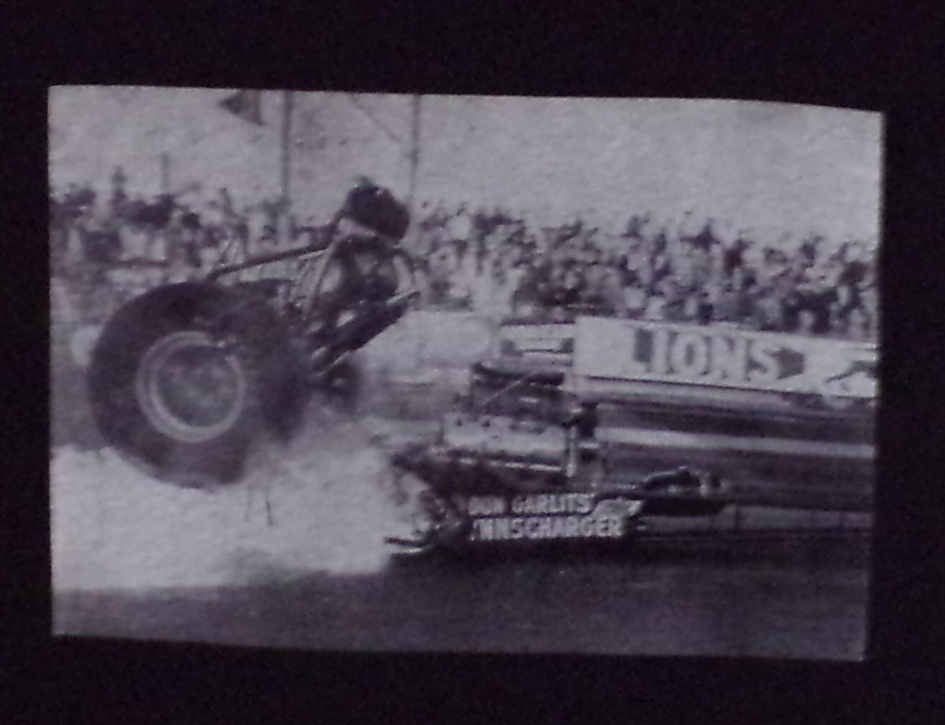 Black “Don Big Daddy Garlits – Clutch Explosion” unisex T-shirt featuring a historic black-and-white image from Lions Drag Strip, Small–3XL.