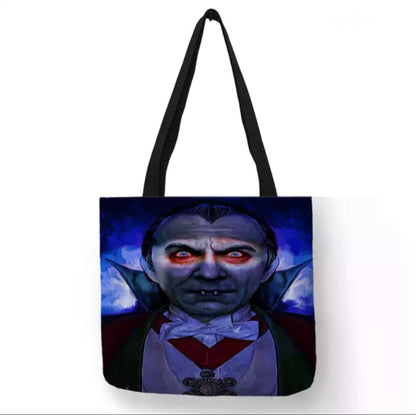 Black double-sided Dracula canvas tote bag featuring a colorful vampire portrait with glowing red eyes, pale blue skin, slicked-back dark hair, and a red bow tie.