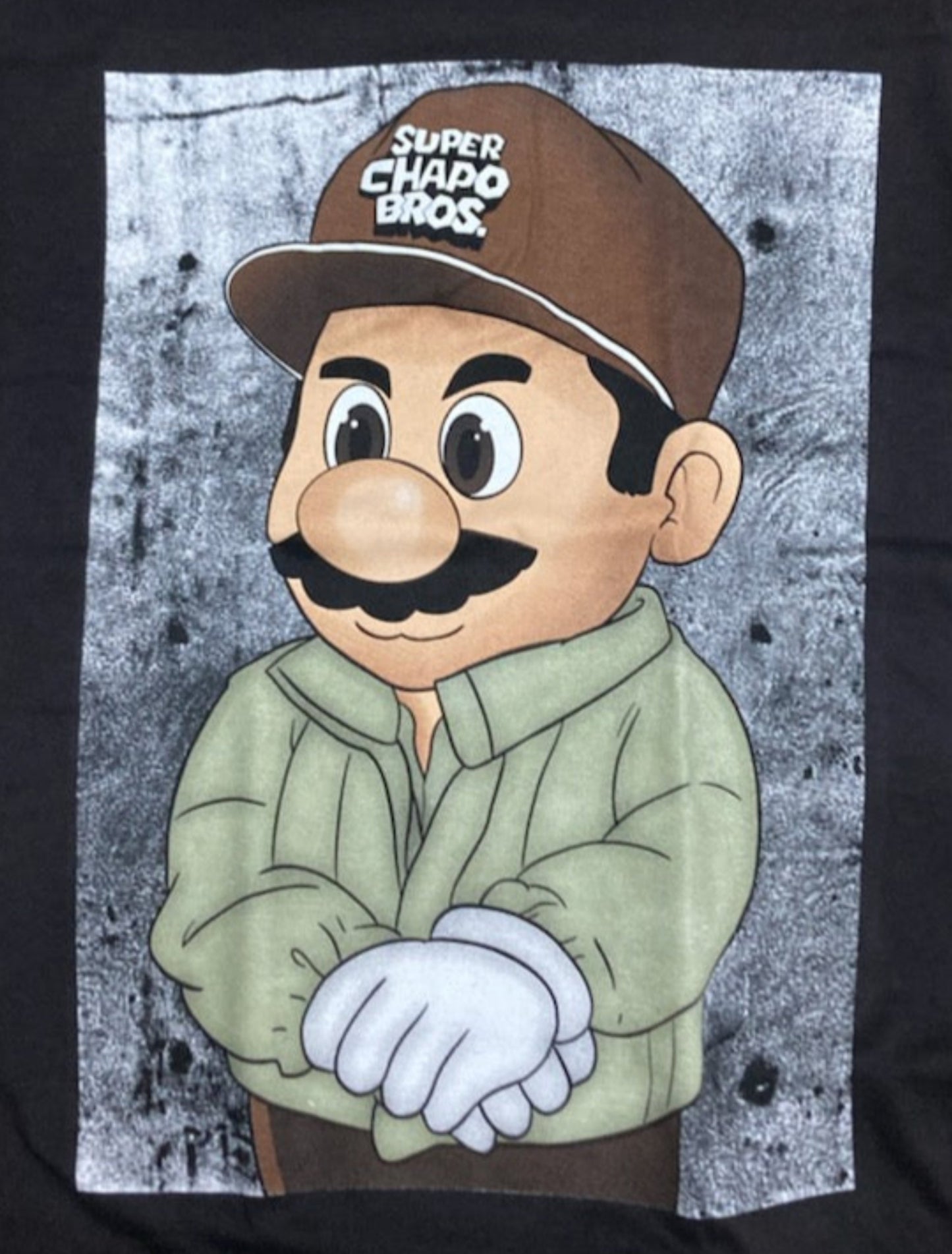 Black “El Super Mario” T-shirt featuring a humorous parody design inspired by Mexican culture and pop art style.