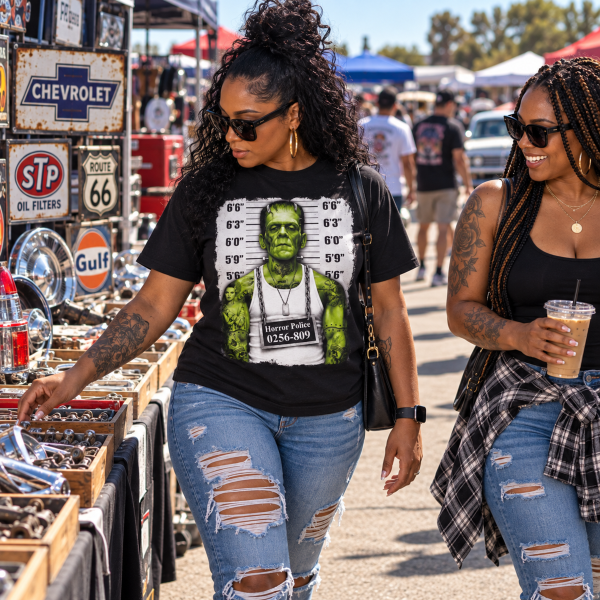 Woman wearing the Frankenstein Monster Mugshot black T-shirt while shopping with a friend at an outdoor swap meet surrounded by vintage automotive merchandise.