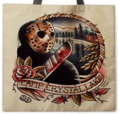 Close-up of Friday the 13th Camp Crystal Lake tote bag artwork showing Jason Voorhees with his hockey mask and machete against a vintage wooded campground scene.