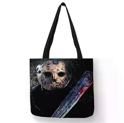 Black Friday the 13th Jason Machete Mask canvas tote bag featuring Jason Voorhees wearing his weathered hockey mask with a large blood-splattered machete positioned diagonally across the dark horror artwork.