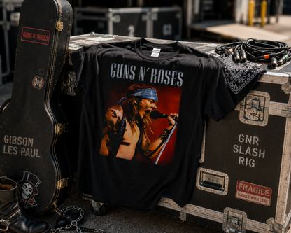 Guns N’ Roses Axl Rose black graphic T-shirt displayed with guitar cases and touring gear, showcasing the live performance artwork for GNR and classic rock fans.