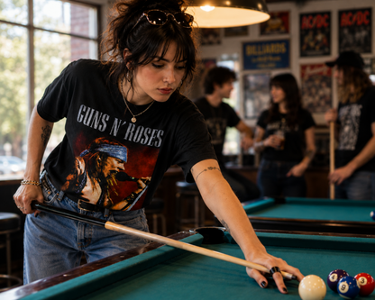 Guns N’ Roses Axl Rose black graphic T-shirt worn while playing pool, pairing his blue-bandana performance artwork with an unmistakable hard rock look.