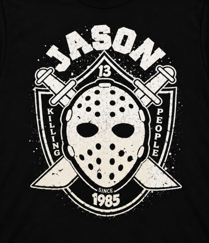 Close-up of the Jason Voorhees black graphic T-shirt featuring his weathered hockey mask, crossed machetes, JASON lettering and 1985 detail.