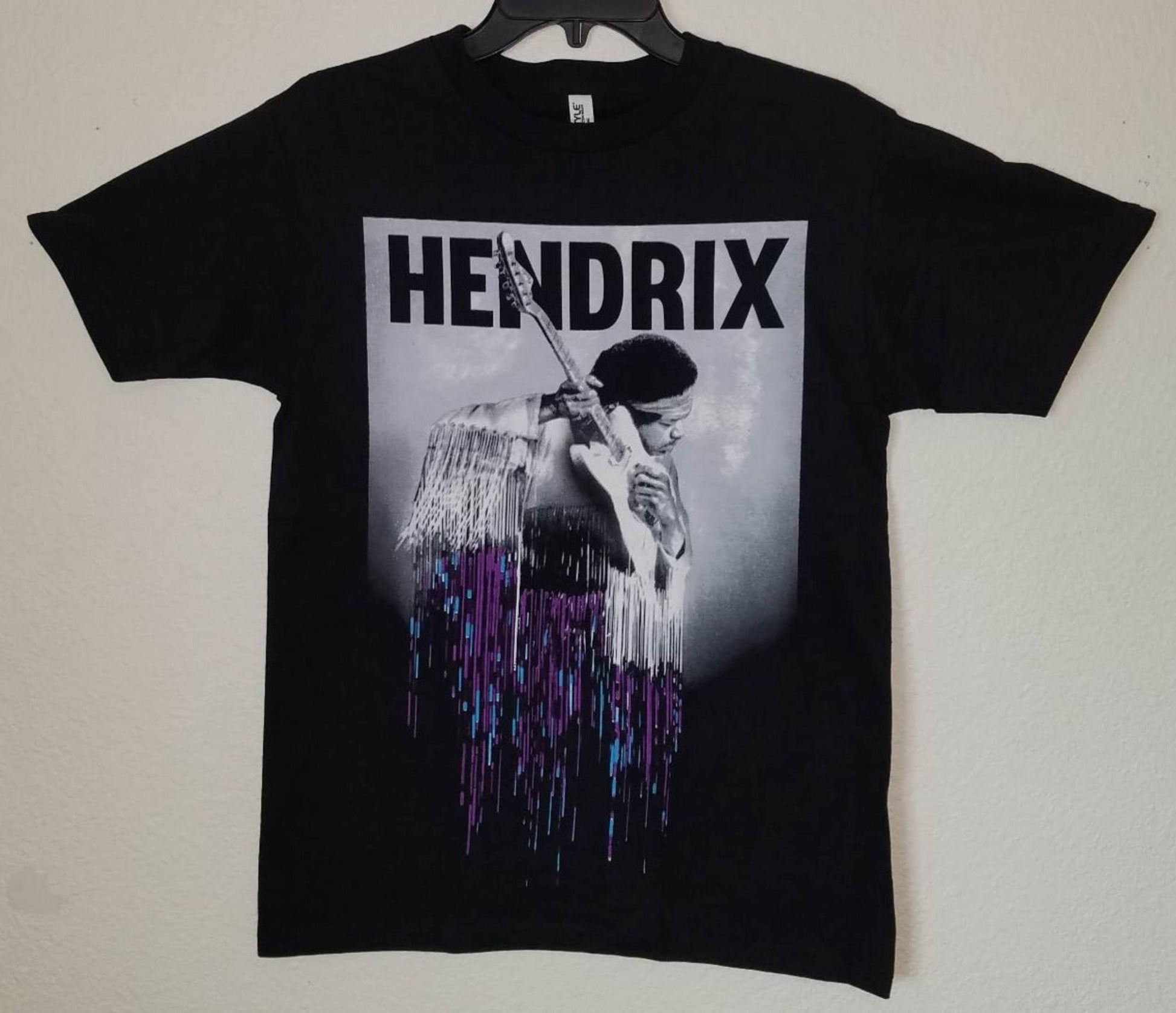 Black “Jimi Hendrix – Purple Drip” unisex T-shirt featuring Hendrix with guitar and a dripping purple-blue gradient design, Small–3XL.