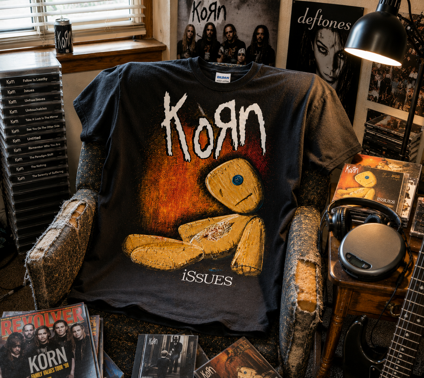Korn Issues rag doll black T-shirt displayed in a music-filled bedroom setting—a nostalgic late-’90s nu metal shirt for Korn fans and collectors.