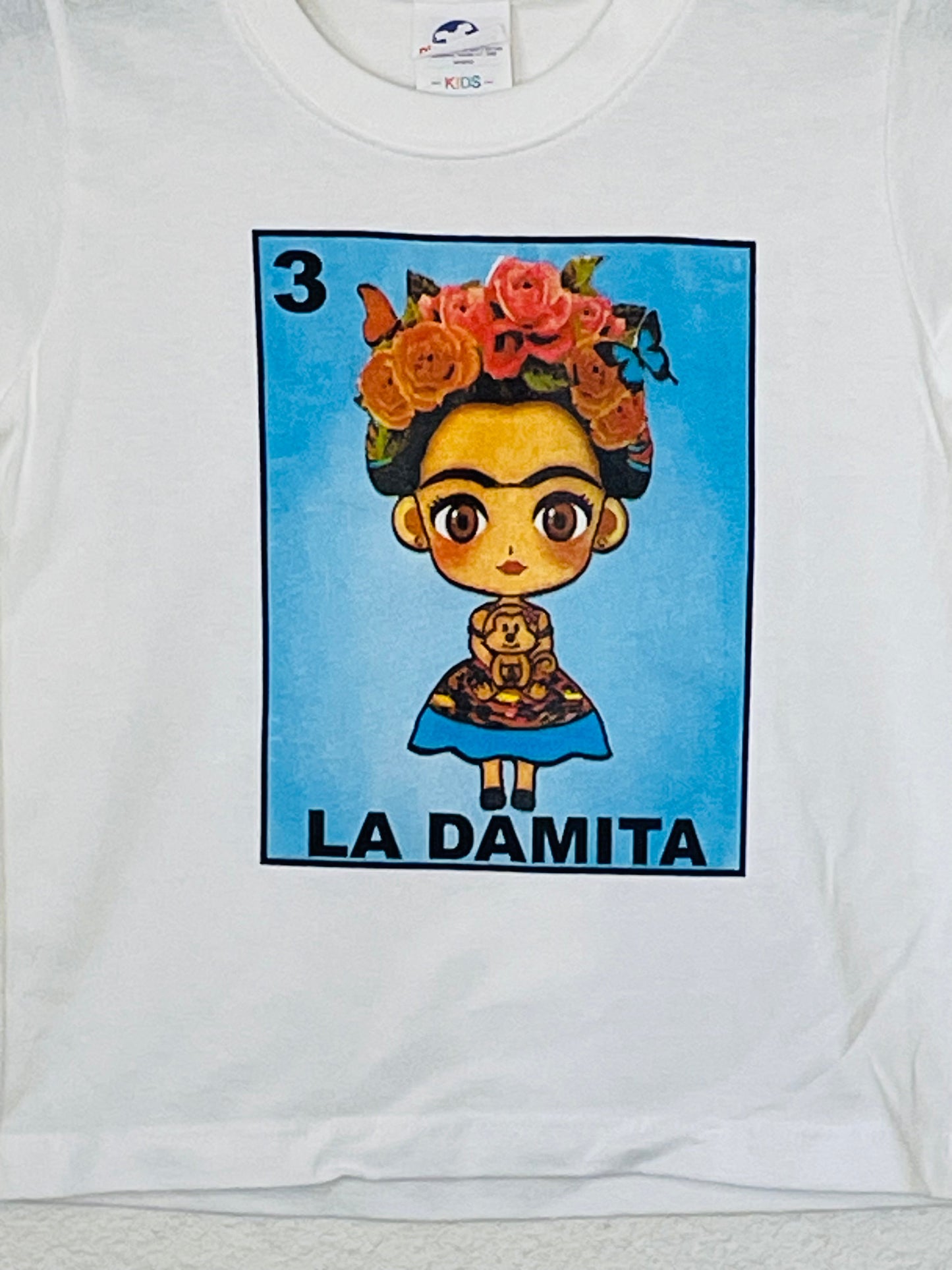 "La Damita" Girls Youth T-Shirt featuring vibrant Lotería-inspired design with a little girl graphic. Available in sizes XS-XL youth from JB Accessories05