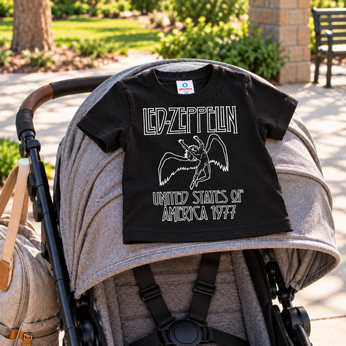 Led Zeppelin America 1977 black infant graphic T-shirt displayed on a stroller outdoors.