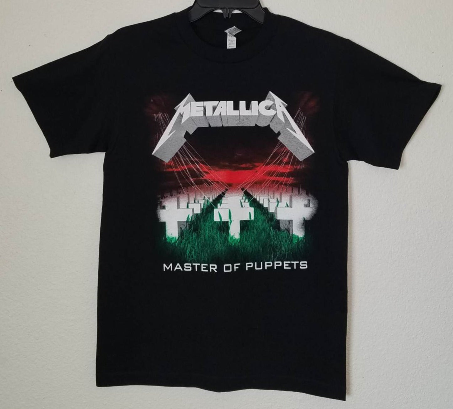 Front view of Metallica Master of Puppets graphic T-shirt featuring crosses field and red sky album artwork on black tee