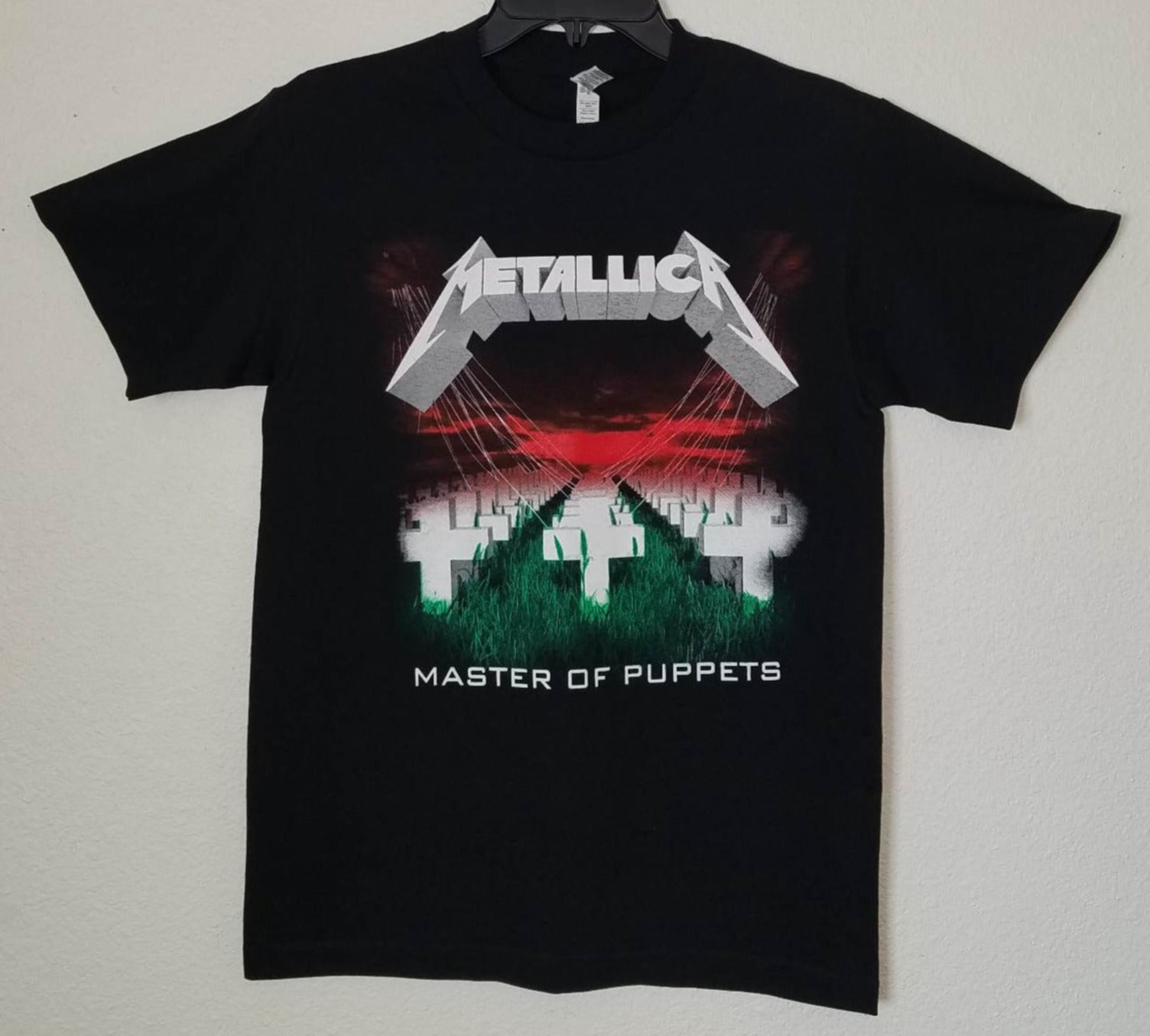 Front view of Metallica Master of Puppets graphic T-shirt featuring crosses field and red sky album artwork on black tee