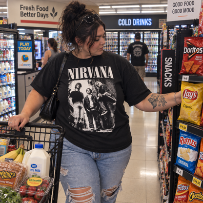 Woman wearing the Nirvana Alleyway Band Photo black graphic T-shirt in a record store, showing how the distressed band design looks as an everyday Nirvana shirt.
