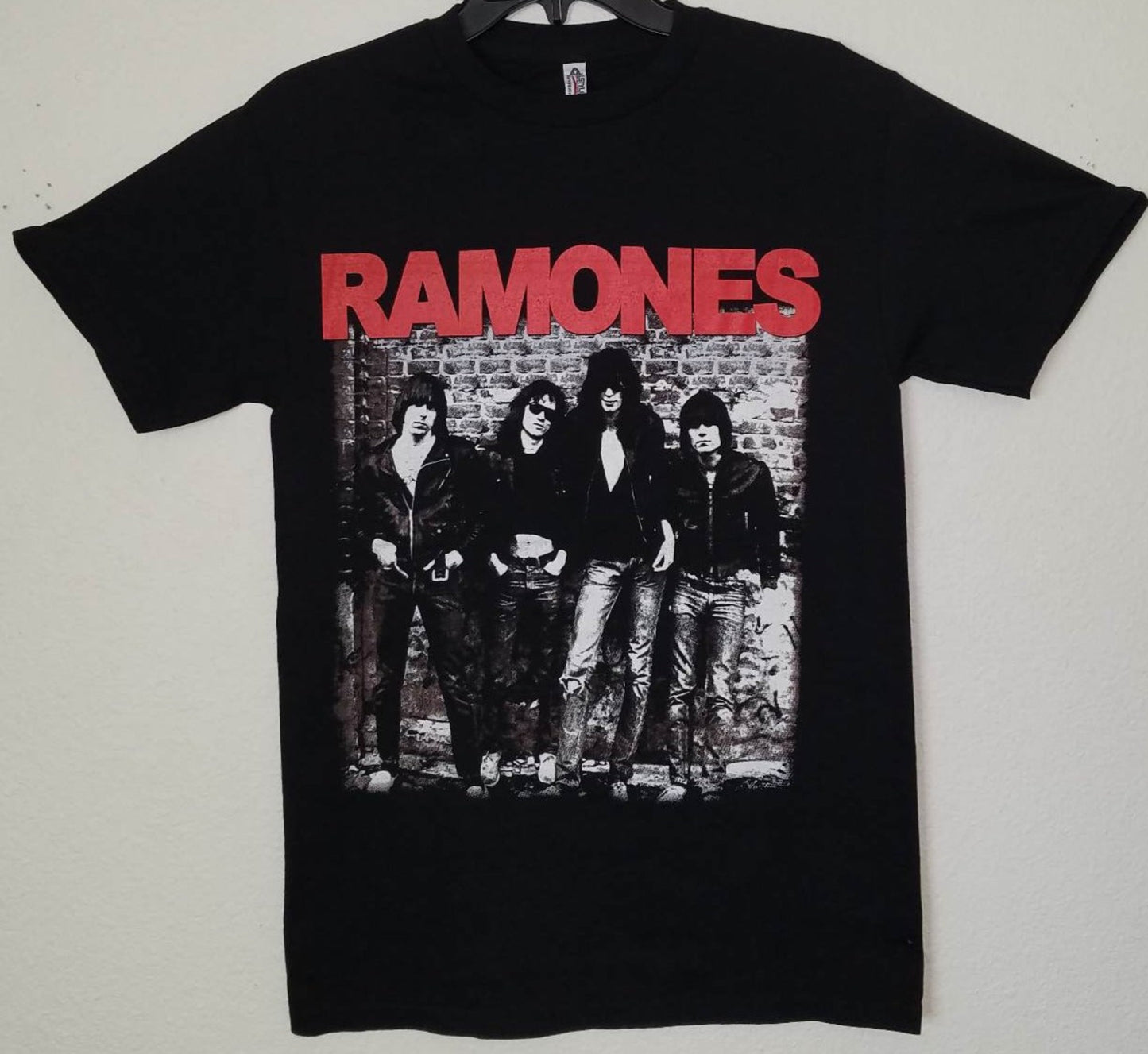 Front view of Ramones 1976 debut album band graphic T-shirt featuring classic black-and-white punk photo on black cotton tee