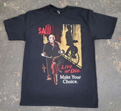 Black Saw t-shirt featuring Billy the Puppet on a tricycle with “Live or Die, Make Your Choice” text – Unisex Silkscreen