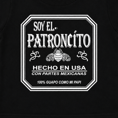 Close-up of the Soy El Patroncito and Hecho en USA con Partes Mexicanas graphic on the black infant T-shirt.