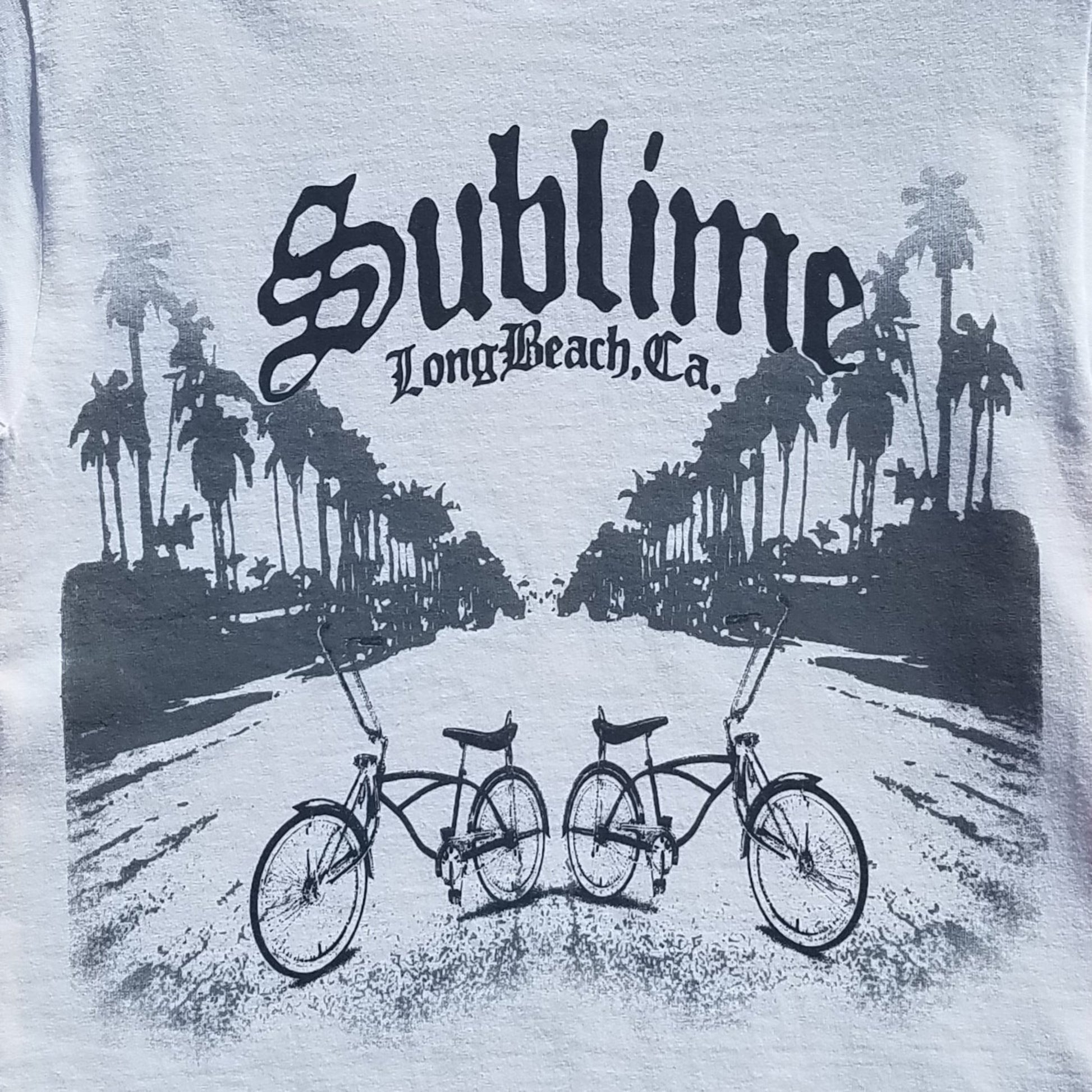 Front view of Sublime Long Beach Bikes graphic T-shirt featuring palm trees and lowrider bicycles printed in authentic silkscreen on white cotton tee