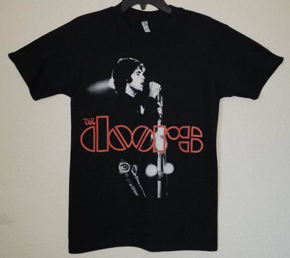 Front view of The Doors In Concert graphic T-shirt featuring Jim Morrison performing live with red logo printed in silkscreen on black cotton tee