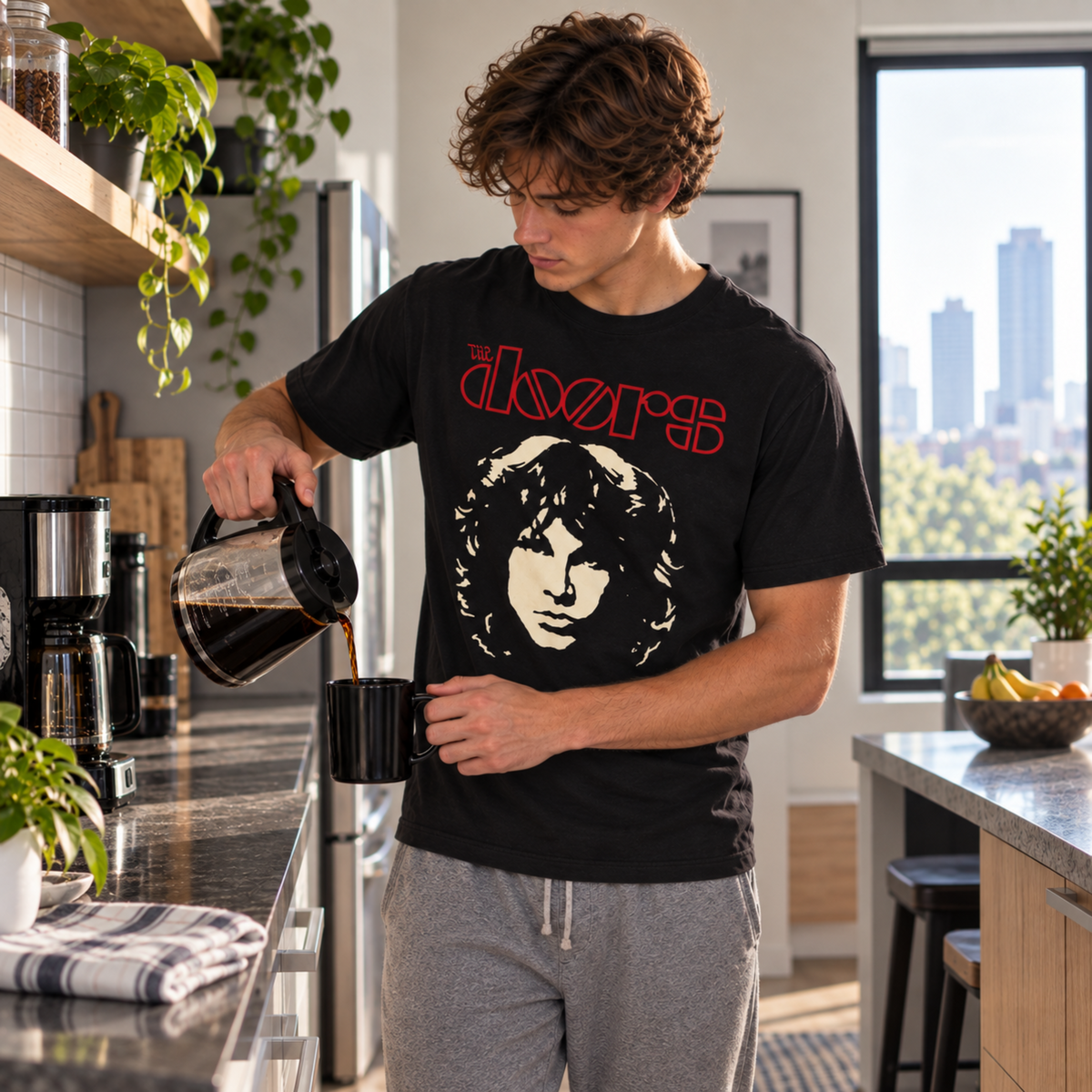 Man wearing The Doors Jim Morrison Face black T-shirt while pouring coffee, featuring the Morrison portrait and red The Doors logo—a standout shirt for classic rock fans.
