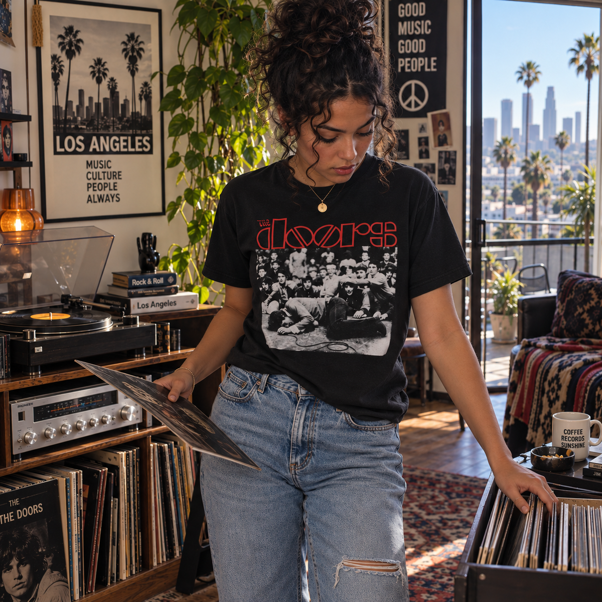 The Doors Jim Morrison Frankfurt 1968 adult unisex graphic T-shirt worn by woman browsing records in a modern Los Angeles apartment, sizes S–3XL