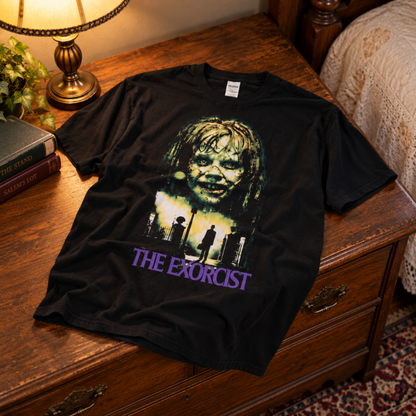 The Exorcist black T-shirt displayed on a bed, featuring Regan MacNeil and Father Merrin—a killer addition to any classic horror collection.