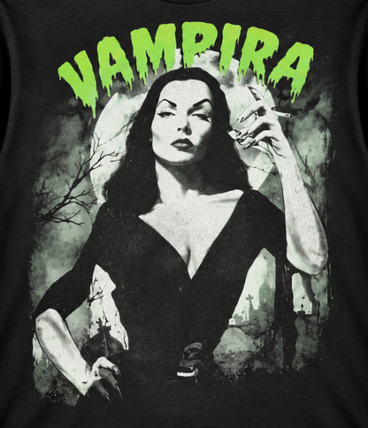 Close-up of the Vampira The Glamour Ghoul black T-shirt showing her dramatic black dress, dark makeup and bright green VAMPIRA lettering.