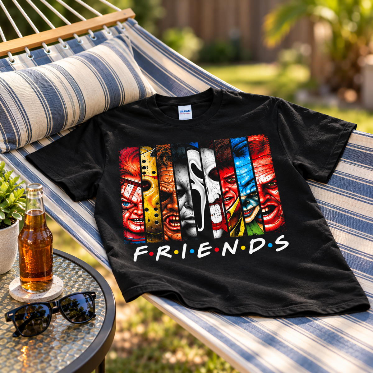 Villain Friends black graphic T-shirt displayed across an outdoor hammock, featuring Chucky, Jason, Leatherface, Michael Myers, Ghostface, Freddy and Pennywise.