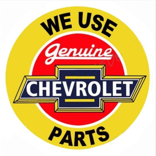 We Use Genuine Chevrolet Parts embossed round aluminum sign with bright yellow background, available in 12 inch and 24 inch diameter, inspired by vintage Chevy service departments.