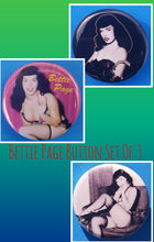 Load image into Gallery viewer, new bettie page button set of 3 fashion buttons are 1.25 inches in size Set Includes Bettie Page Color Picture Bettie Page Holding Whip Bettie Page Sitting With Leg Up
